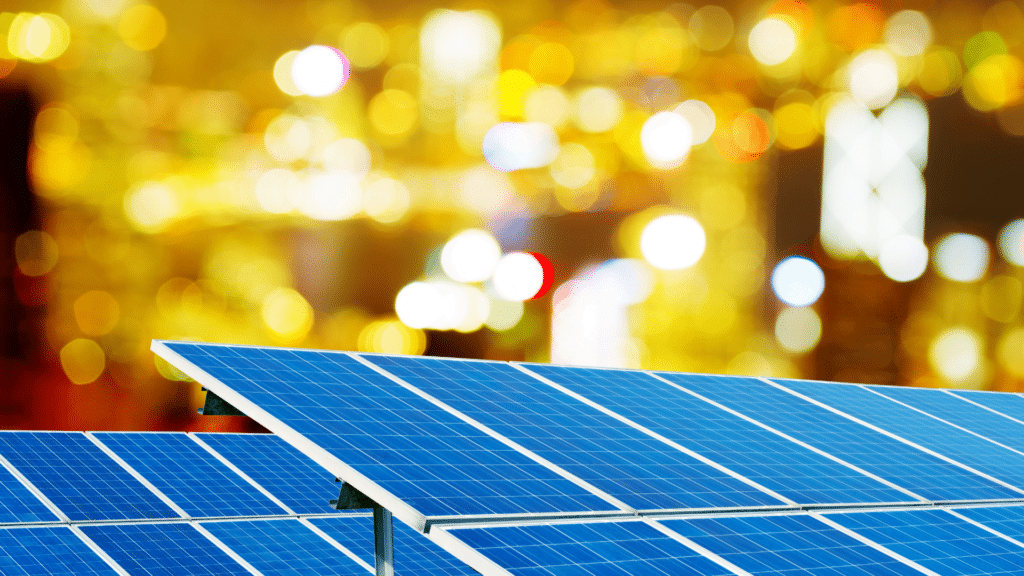 Pannelli fotovoltaici in primo piano con sfondo di luci sfocate della città. Incentivi fotovoltaico per le imprese